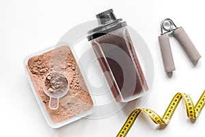 Nutrition for workout with protein cocktail powder, measure tape and bars on white background top view