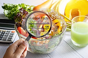 Nutritional information concept. hand use the magnifying glass to zoom in to see the details of the nutrition facts from food