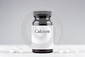 Nutritional supplement calcium bottle and capsules on gray