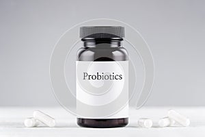 Nutritional supplement probiotics bottle and capsules on gray