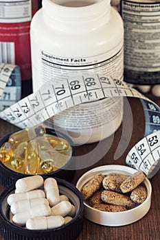 Nutritional supplements in capsules and tablets, on wooden background