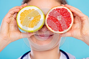 Nutritionist covering her eyes with fruits