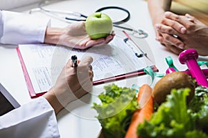 Nutritionist giving consultation to patient with healthy fruit and vegetable, Right nutrition and diet