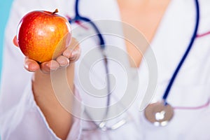 Nutritionist holding apple fruit in her hand