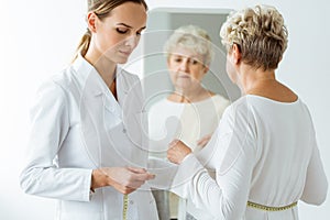 Nutritionist measuring patient`s body circumference