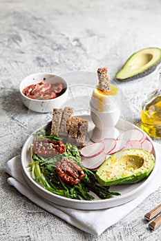 Nutritious breakfast. wild garlic, sun-dried tomatoes, whole grain bread, avocado, seeds and boiled egg. good nutrition concept