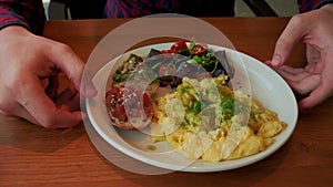 A nutritious brunch serving with fluffy scrambled eggs, a vibrant mixed salad, avocado toast, and seeds.