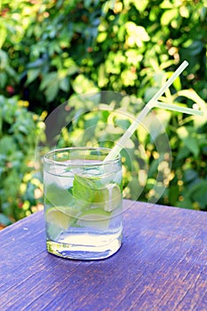 Nutritious detox water with lime and mint in a glass on the wood background