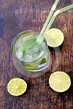Nutritious detox water with lime and mint in a glass on the wood background
