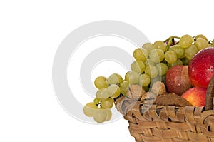 Nuts, apples and grapes in a wicker basket