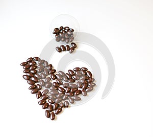 Nuts arranged in heart shape on background. Food image close up candy, chocolate milk, extra dark almond nuts. Love Texture on