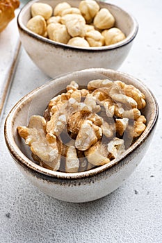Nuts in bowl, on white stone table background