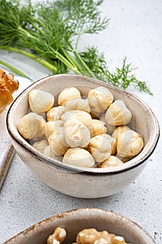 Nuts in bowl, on white stone table background