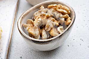 Nuts in bowl, on white stone table background
