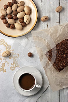 Nuts, chocolate cake and a cup of cofee on the white background