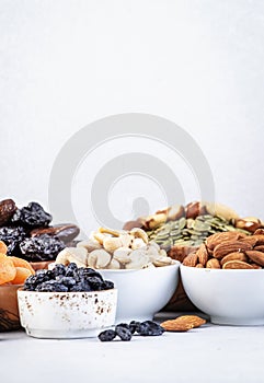 Nuts and dried fruits. Healthy snacks. Dried apricots, figs, raisins, pecans, walnuts, hazelnuts, almonds and other. Gray table