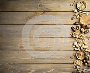 Nuts, dried fruits, honey and old spoons and forks on a wooden table background.
