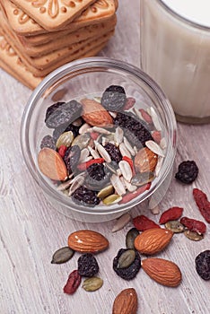 Nuts and Dried Fruits Mix on Rustic Wooden Background. Glass of Milk and Biscuits. Top view.