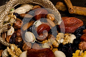 Nuts, dried fruits, pistachios and other scattered from the bag on the table