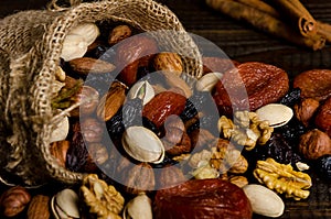 Nuts, dried fruits, pistachios and other scattered from the bag on the table