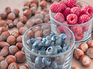 Nuts and juicy seasonal berries in the glassess. Summer and autumn food concept