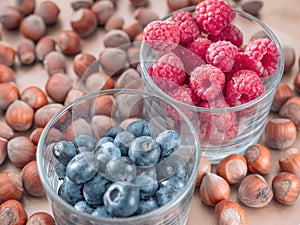 Nuts and juicy seasonal berries in the glassess. Summer and autumn food concept