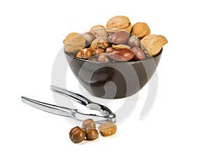 Nuts mix in brown plate and silver nutcracker