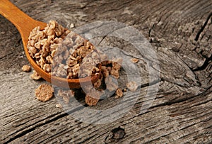 Nuts muesli in a wooden spoon on natural wooden background