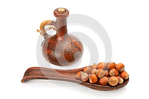 Nuts and nut oil in clay bottle isolated on white background