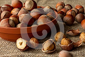 Whole nuts in the shell are on the plate and on the table. Close-up.