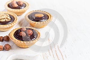 Nutty chocolate dessert small tarts on a white background, spac