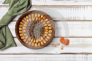 Nutty gluten-free cake with apricot nuts and pumpkin seeds  with filling  on a light wooden background. Rustic style