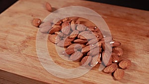 nutty perfection: woman hands cutting, chopping almonds closeup on wooden board