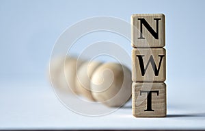 NWT - acronym on a wooden block on a white background with wooden balls