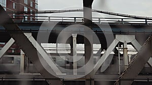 NY City subway train passing in the background, beyond the Iron bars of the bridge