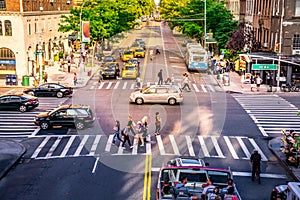 NYC intersection crowded with busy people, cars and yellow taxis. Iconic traffic and daily street business in Manhattan