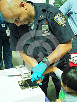 NYC Police finger printing a child for Safe card program