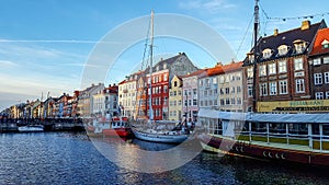 Nyhavn waterfront, canal, colorful facades of old house reflection, and buildings, ships, yachts and boats in Copenhagen, Denmark