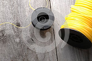 Nylon grass trimmer line and trimmer head on an old wooden background with copy space