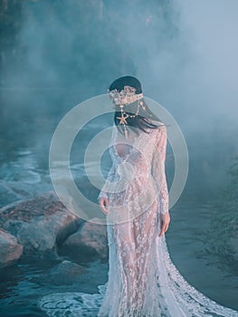 Nymph, walks in the river which was tightened by a thick, impenetrable fog. She has a white vintage, lacy dress. Feast