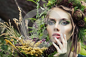 Nymph woman with wild flowers outdoor, close up portrait