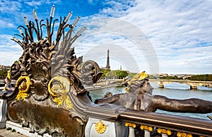 Nymphs of the seine gilded statue on the Alexander III Bridge with the Eiffel Tower in the background in Paris