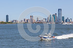 NYPD boat patrolling East River. In the background skyscrapers New Jersey.