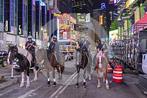 NYPD police officers on horseback in Times Square, New York City. Mounted Police patrolling the night in Times Square