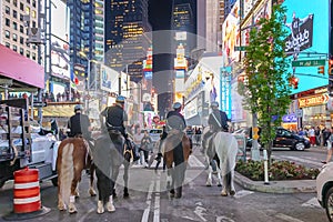 NYPD police officers on horseback in Times Square, New York City. Mounted Police patrolling the night in Times Square