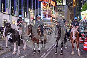 NYPD police officers on horseback in Times Square, New York City. Mounted Police patrolling the night in Times Square