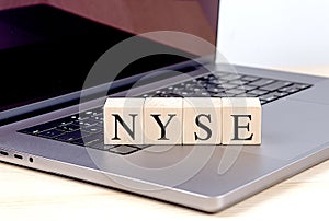 NYSE word on wooden block on laptop , business concept