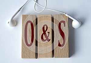 O and S - acronym on wooden blocks on white background with wired headphones