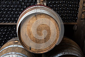 Oak barrels with wine bottles