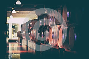 Oak barrels with wine in dark cellar. Modern production of wine with the observance of age-old traditions.